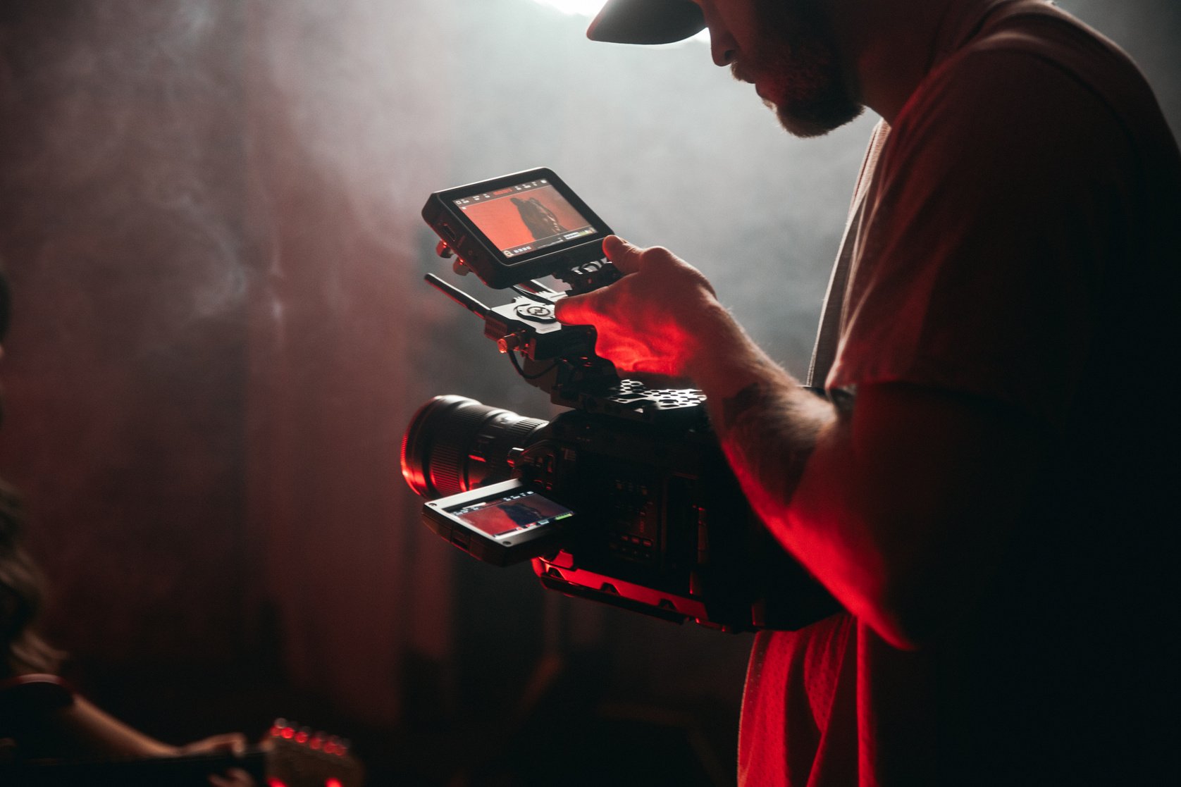 Photo of a Man Using a Camera Near Smoke